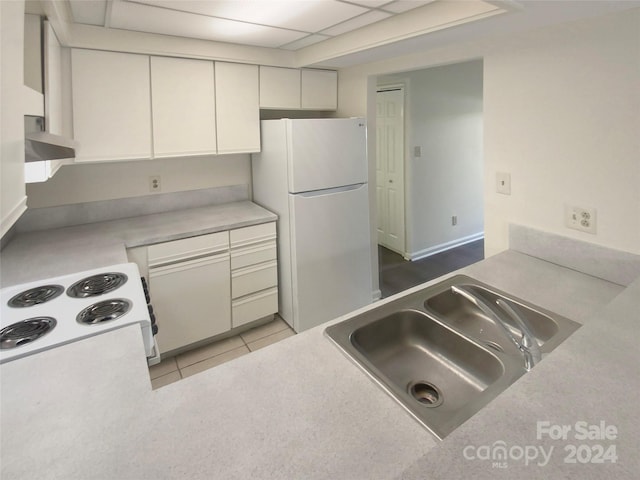 kitchen featuring sink, a drop ceiling, light tile patterned floors, white cabinetry, and white appliances