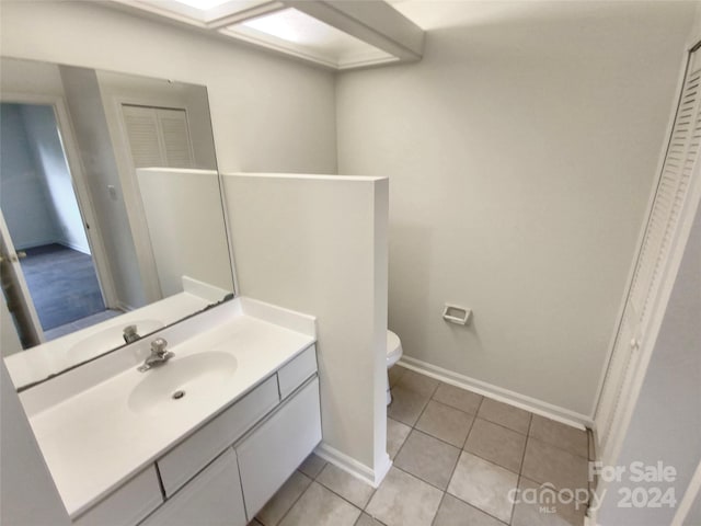 bathroom featuring toilet, vanity, and tile patterned flooring