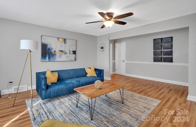 living room featuring hardwood / wood-style floors, a textured ceiling, and ceiling fan