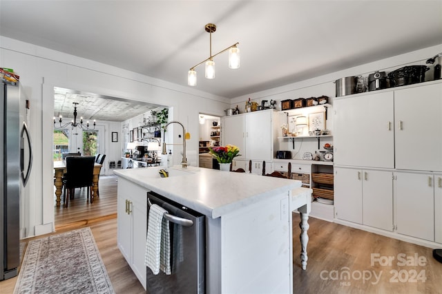 kitchen with hanging light fixtures, white cabinetry, stainless steel refrigerator, light hardwood / wood-style flooring, and a center island