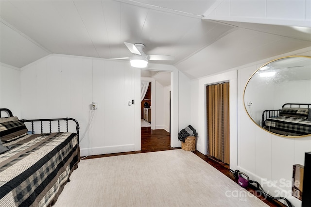 bedroom featuring lofted ceiling, wood walls, ceiling fan, and dark hardwood / wood-style flooring