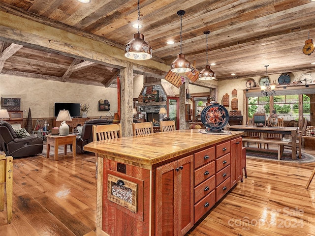 kitchen featuring wood ceiling, a kitchen island, a chandelier, light hardwood / wood-style flooring, and pendant lighting