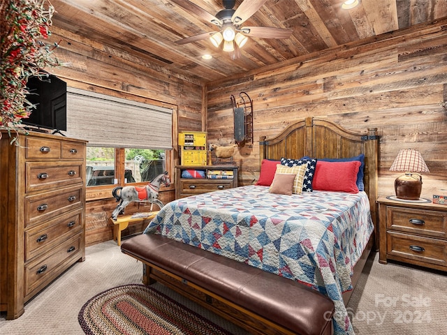 carpeted bedroom featuring wood walls, ceiling fan, and wooden ceiling