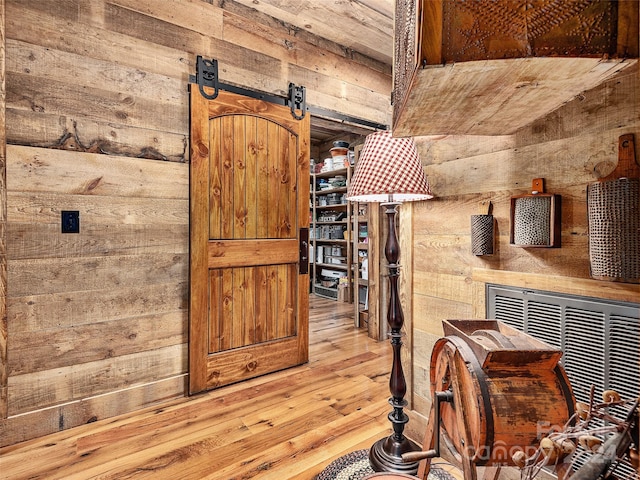 interior space featuring wood walls, a barn door, and wood-type flooring