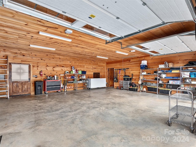 garage featuring a workshop area and wood walls