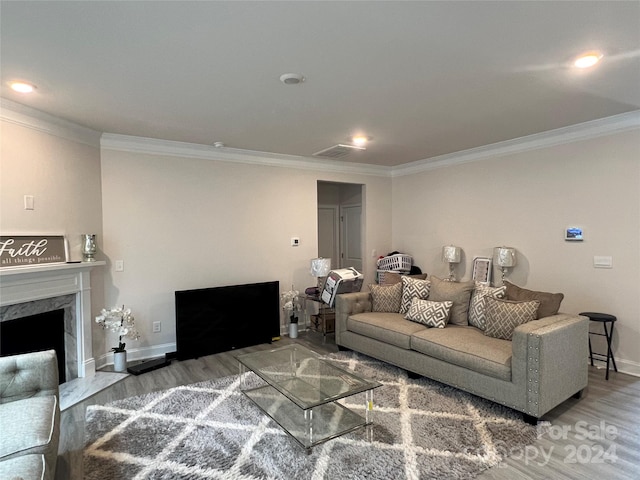 living room featuring ornamental molding, a premium fireplace, and wood-type flooring