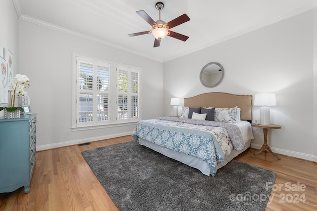 bedroom featuring ceiling fan, hardwood / wood-style flooring, and crown molding