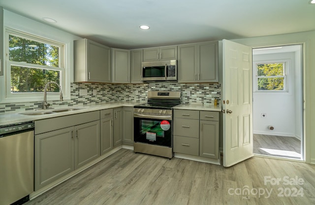 kitchen featuring a wealth of natural light, sink, appliances with stainless steel finishes, and light hardwood / wood-style flooring