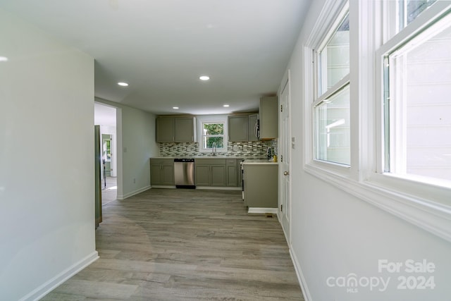 kitchen with decorative backsplash, gray cabinets, dishwasher, light hardwood / wood-style floors, and sink