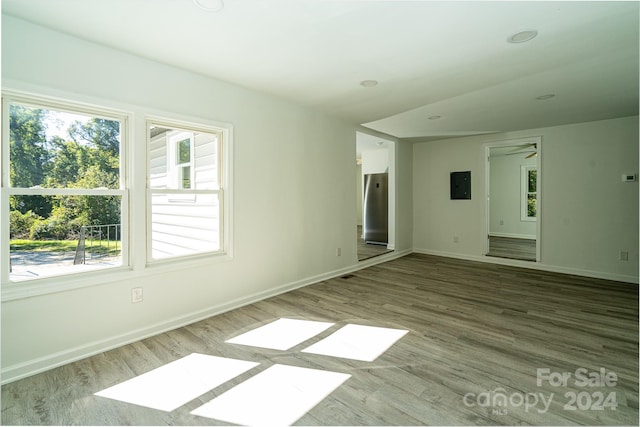 empty room featuring ceiling fan, electric panel, and hardwood / wood-style floors