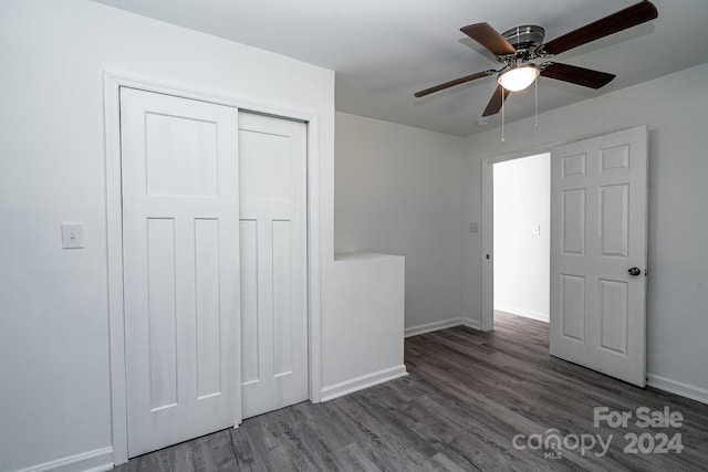 unfurnished bedroom with a closet, ceiling fan, and dark hardwood / wood-style floors