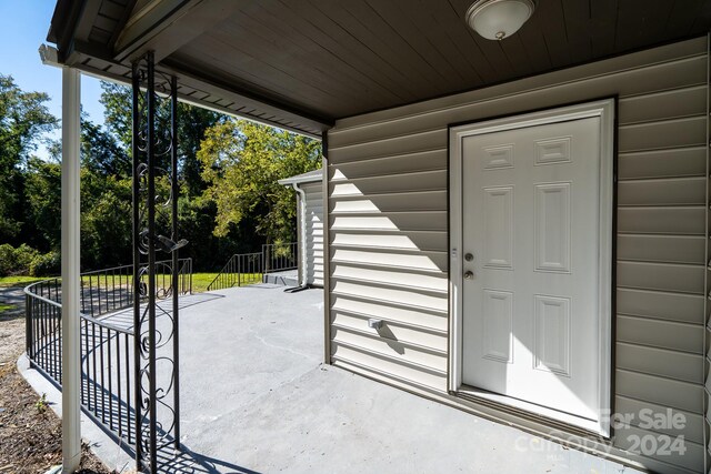 view of exterior entry with a patio area