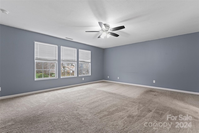 carpeted spare room featuring ceiling fan