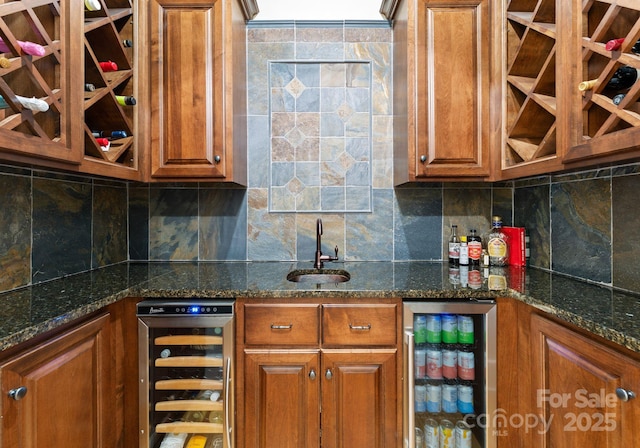 kitchen with sink, dark stone counters, and wine cooler