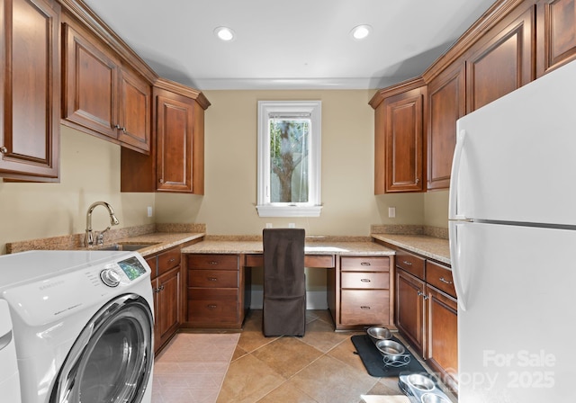 washroom with sink, washer and clothes dryer, and light tile patterned floors