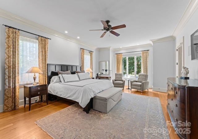 bedroom with ceiling fan, crown molding, and light wood-type flooring