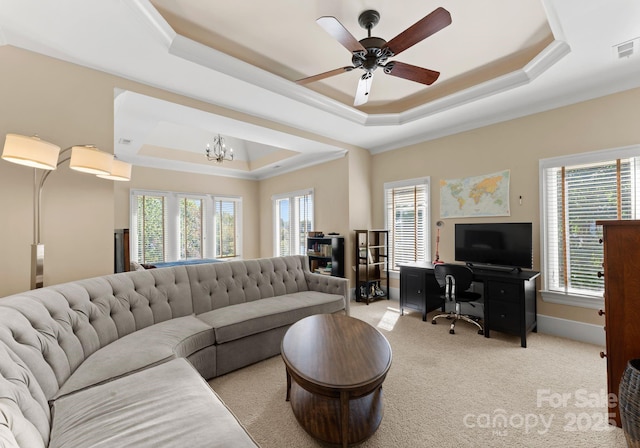 living room featuring ceiling fan with notable chandelier, plenty of natural light, and a tray ceiling