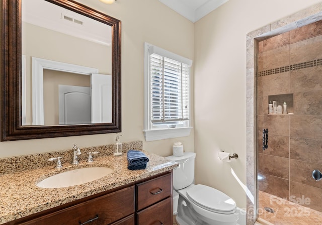 bathroom featuring toilet, a shower with door, and vanity