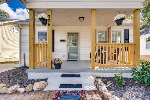 view of exterior entry featuring covered porch