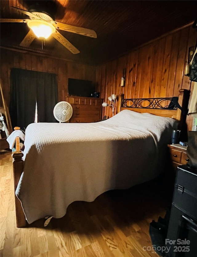 bedroom featuring ceiling fan, wooden ceiling, and wood walls