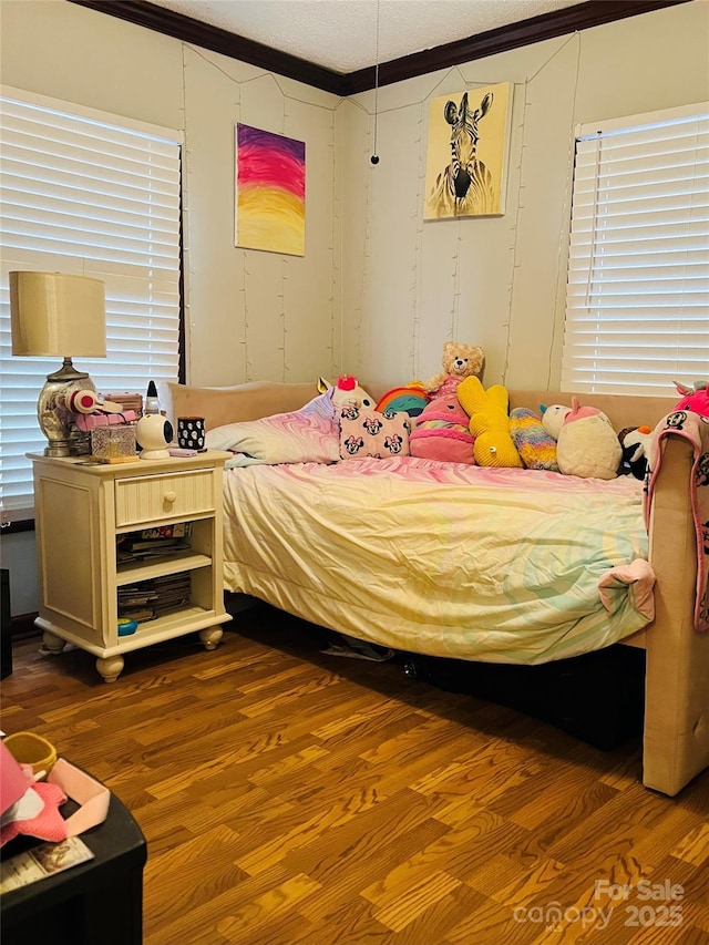 bedroom with ornamental molding and hardwood / wood-style floors