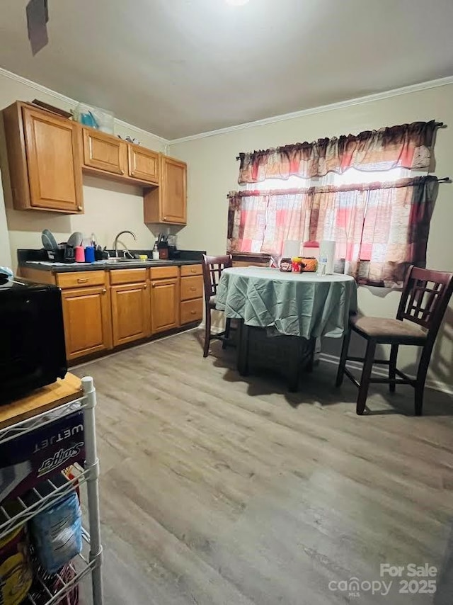 kitchen featuring sink, crown molding, and light hardwood / wood-style flooring