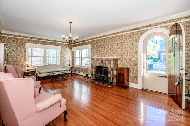 living room with ornamental molding, a chandelier, wood-type flooring, and a healthy amount of sunlight