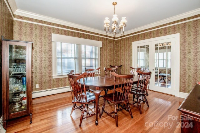 dining area with baseboard heating, ornamental molding, wood-type flooring, and an inviting chandelier