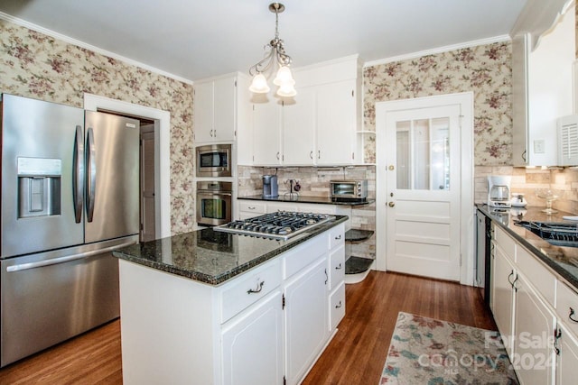 kitchen with a kitchen island, crown molding, white cabinetry, appliances with stainless steel finishes, and dark hardwood / wood-style flooring