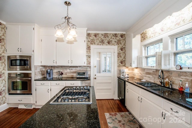 kitchen with sink, appliances with stainless steel finishes, white cabinetry, and dark hardwood / wood-style flooring