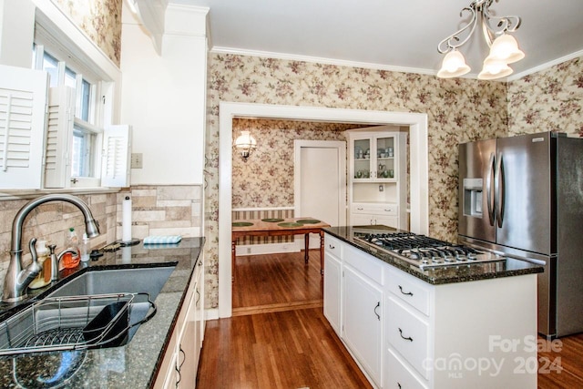 kitchen featuring appliances with stainless steel finishes, dark wood-type flooring, decorative light fixtures, and sink