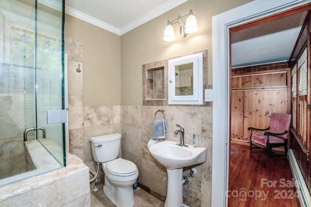 bathroom featuring a baseboard heating unit, hardwood / wood-style floors, tile walls, toilet, and ornamental molding