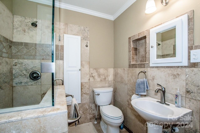 bathroom featuring a tile shower, tile walls, toilet, ornamental molding, and sink