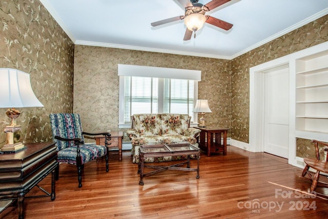 living room with ornamental molding, hardwood / wood-style floors, built in shelves, and ceiling fan