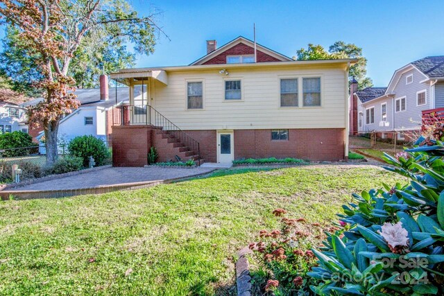 rear view of property with a yard