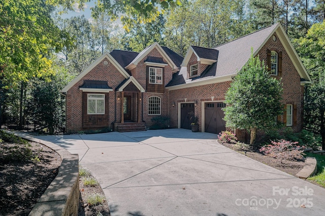 view of front of house featuring driveway, an attached garage, and brick siding