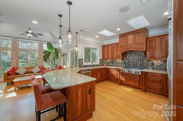 kitchen featuring a breakfast bar area, hanging light fixtures, appliances with stainless steel finishes, open floor plan, and a peninsula