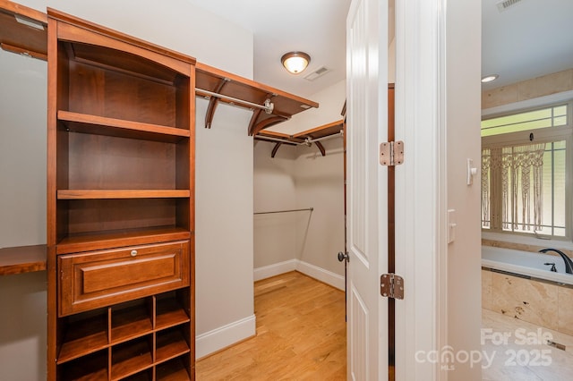 spacious closet with light wood-type flooring and visible vents