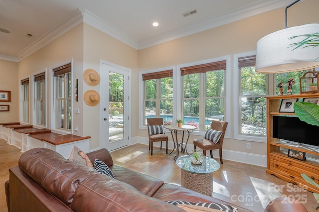 living room with ornamental molding, visible vents, and baseboards