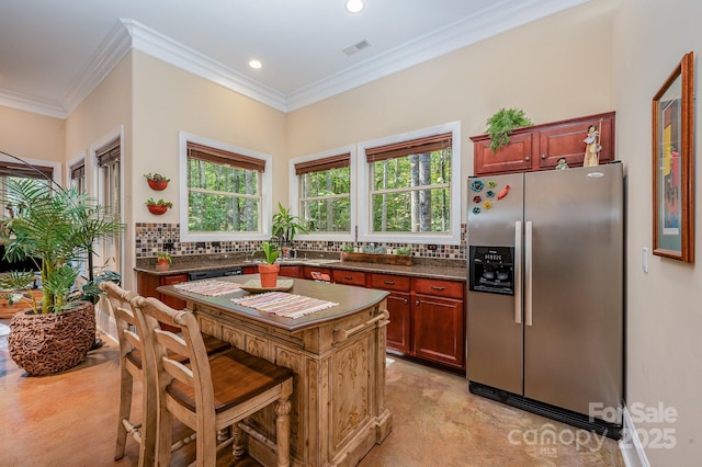 kitchen with visible vents, dark countertops, ornamental molding, stainless steel appliances, and backsplash