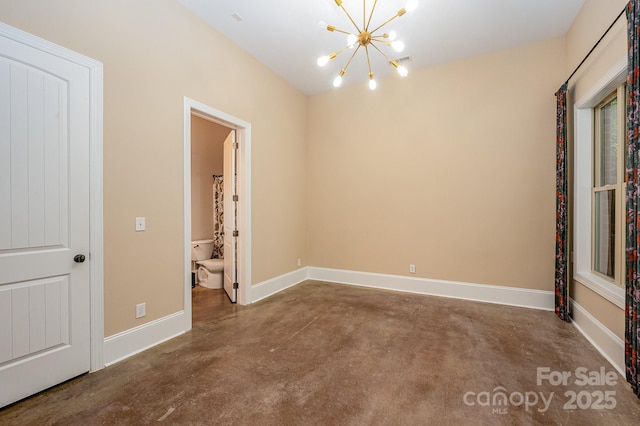 unfurnished room with a notable chandelier, baseboards, and concrete flooring