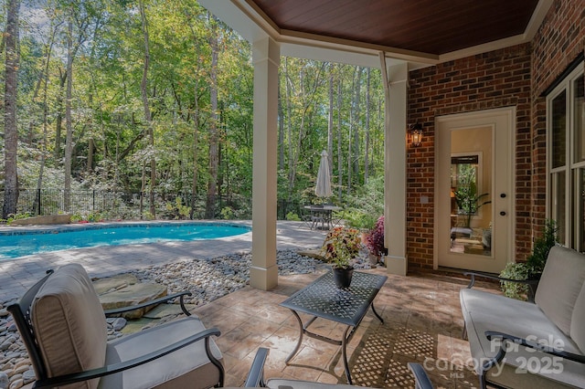 view of patio with fence and an outdoor pool