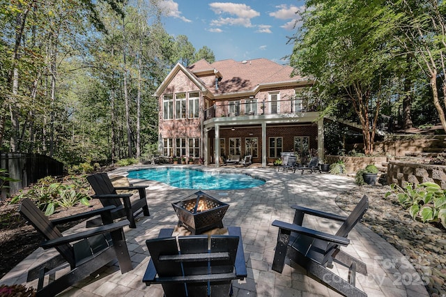 view of swimming pool featuring an outdoor fire pit, a fenced in pool, and a patio