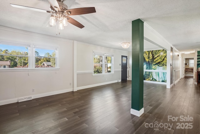 unfurnished room with crown molding, dark wood-type flooring, a textured ceiling, and a wealth of natural light