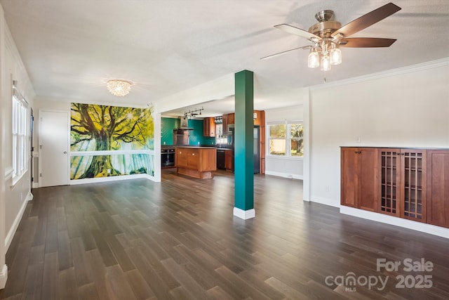 unfurnished living room with plenty of natural light, dark wood-type flooring, ceiling fan, and ornamental molding