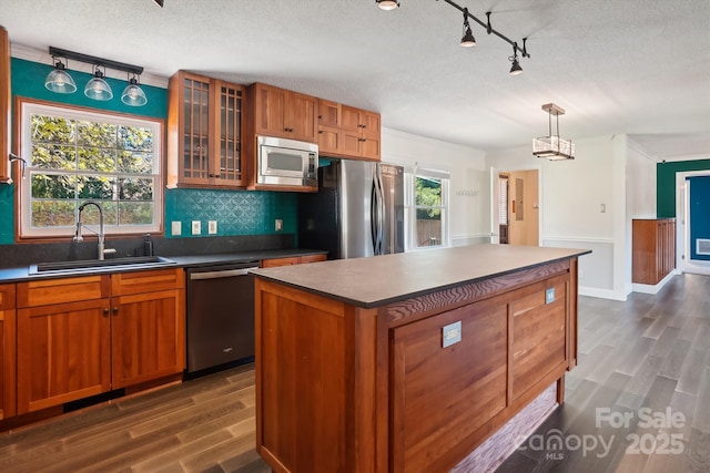 kitchen featuring pendant lighting, sink, dark hardwood / wood-style floors, a kitchen island, and stainless steel appliances