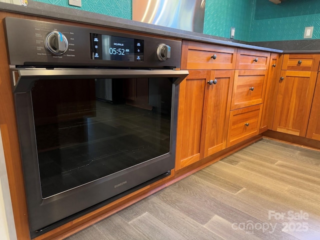 details featuring oven and light hardwood / wood-style flooring