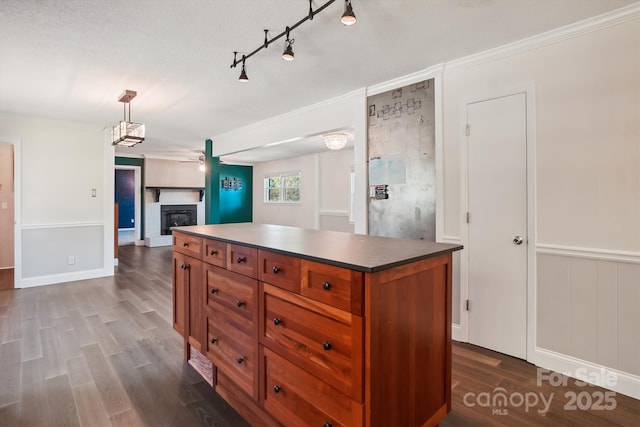 kitchen with a kitchen island, a textured ceiling, hanging light fixtures, and dark hardwood / wood-style flooring