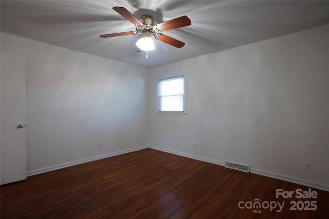 empty room with ceiling fan and dark hardwood / wood-style flooring