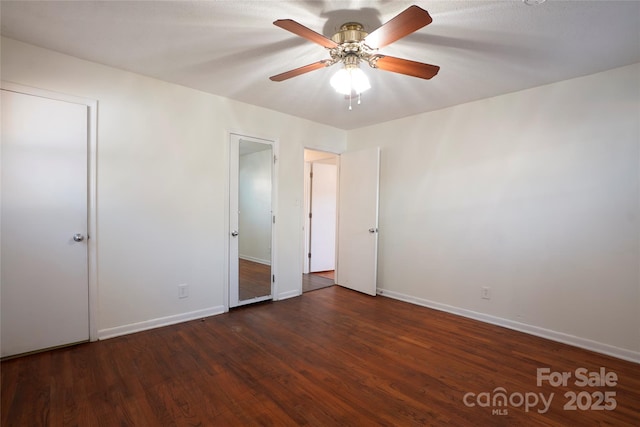 unfurnished bedroom featuring ceiling fan and dark hardwood / wood-style flooring